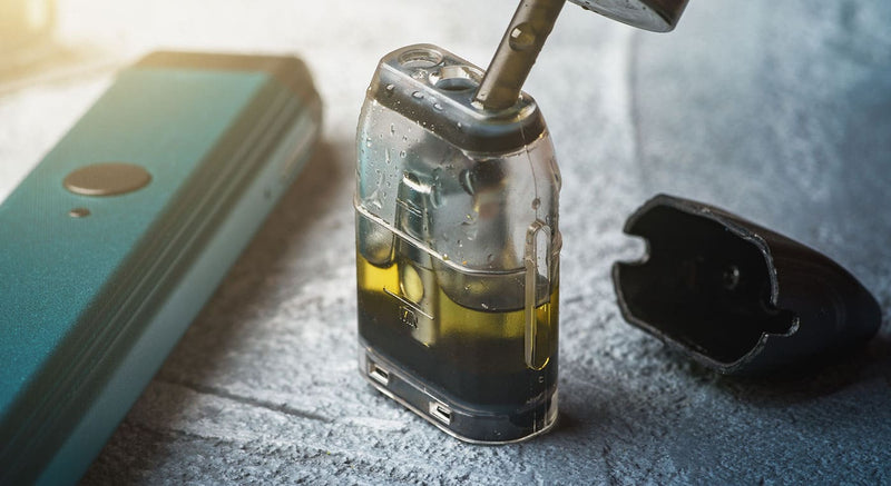 Close up of vape pod being filled with nic salt e-liquid.