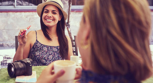 Woman sat at restaurant table vaping e-cigarette in public. Vaping in public guide cover photo.